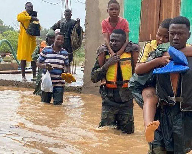 Rescue workers carrying a flood victim to safety